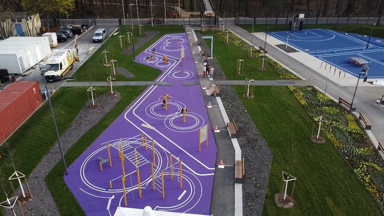 Violette Bewegungsfläche mit weißen Linien und gelben Trainingsgeräten.